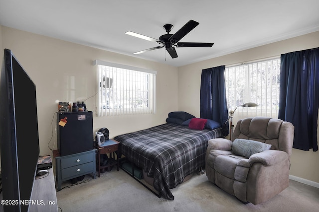 bedroom featuring baseboards, multiple windows, a ceiling fan, and carpet flooring