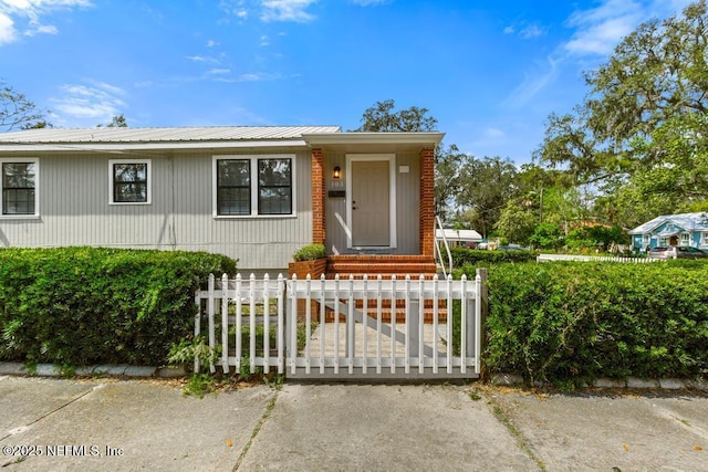 view of front of house featuring a fenced front yard and metal roof