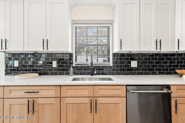 kitchen with a sink, decorative backsplash, stainless steel dishwasher, and light brown cabinetry