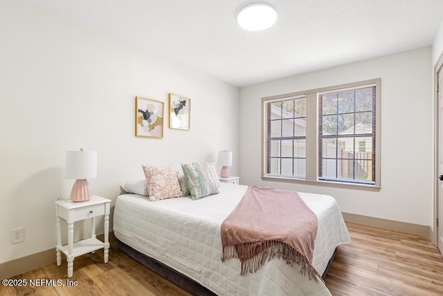 bedroom with wood finished floors and baseboards