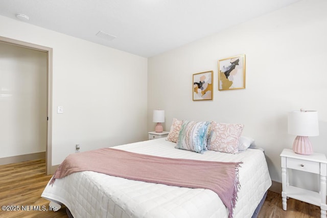 bedroom featuring baseboards and wood finished floors