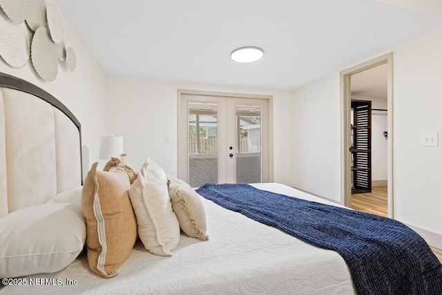 bedroom featuring french doors, wood finished floors, and access to outside