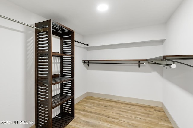 walk in closet with wood finished floors