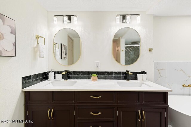 bathroom featuring a sink, a bathtub, and double vanity