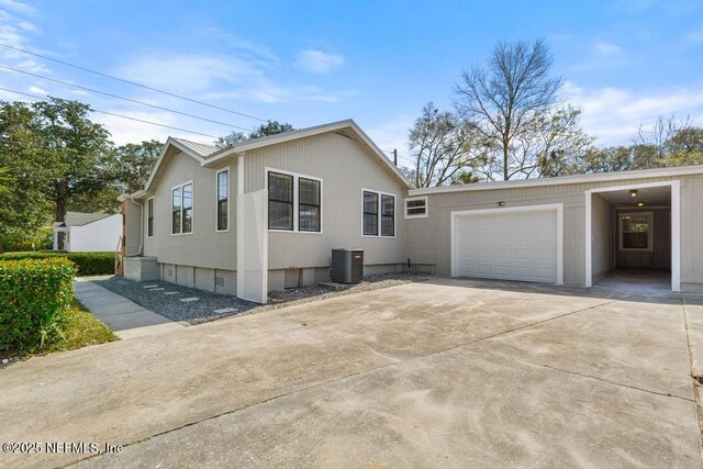 view of side of home featuring crawl space, a garage, central AC, and driveway