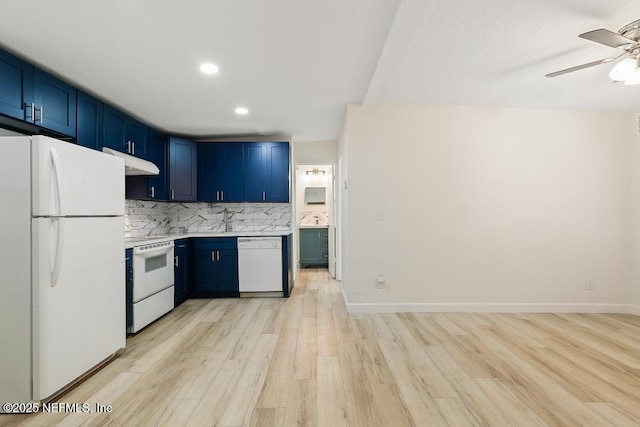 kitchen with white appliances, a ceiling fan, blue cabinetry, under cabinet range hood, and tasteful backsplash