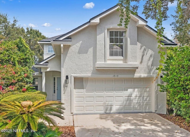 view of front of home with concrete driveway, a garage, and stucco siding