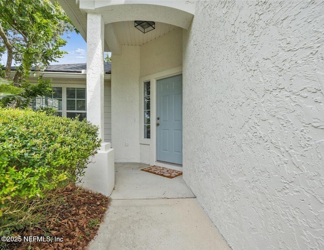 view of exterior entry with stucco siding