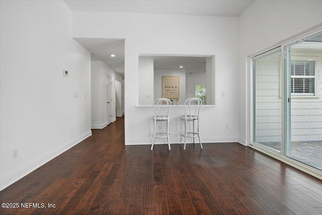 unfurnished dining area featuring recessed lighting, baseboards, and wood-type flooring