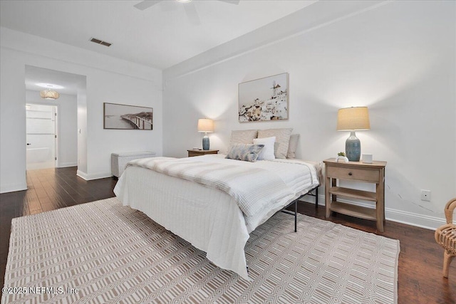 bedroom featuring visible vents, baseboards, a ceiling fan, and hardwood / wood-style flooring