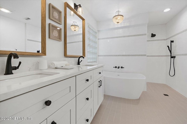 bathroom featuring a sink, a soaking tub, double vanity, and a walk in shower