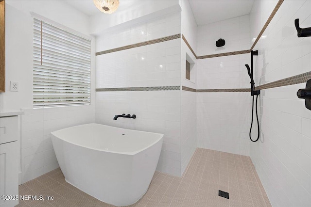 full bathroom with tile patterned flooring, a soaking tub, tile walls, and tiled shower