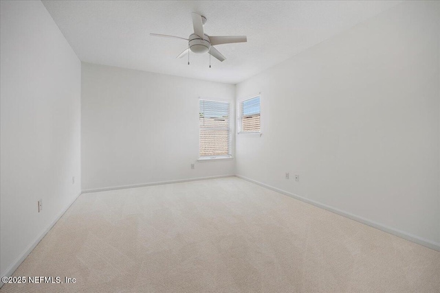 carpeted empty room with baseboards and ceiling fan