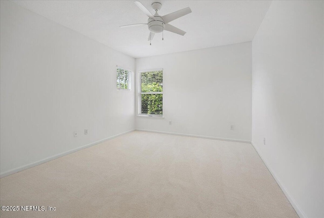 spare room with baseboards, carpet floors, and a ceiling fan