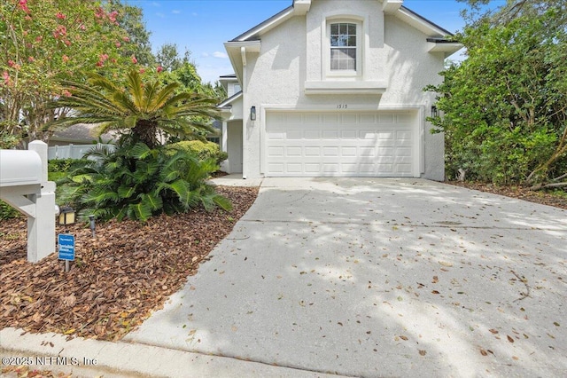 view of front of home featuring stucco siding, driveway, and a garage