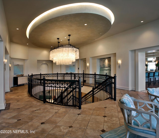 hall with visible vents, baseboards, an upstairs landing, recessed lighting, and an inviting chandelier