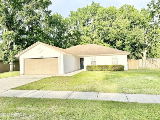 single story home featuring fence, a front yard, stucco siding, a garage, and driveway