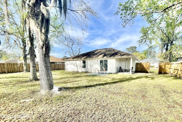 back of property with a patio area, a fenced backyard, and a lawn