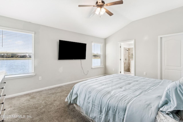 bedroom featuring baseboards, vaulted ceiling, carpet floors, ensuite bath, and a ceiling fan