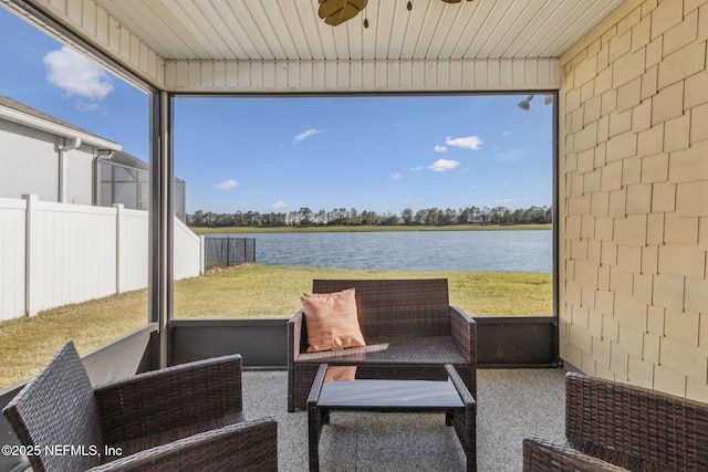 sunroom featuring wood ceiling, a ceiling fan, and a water view