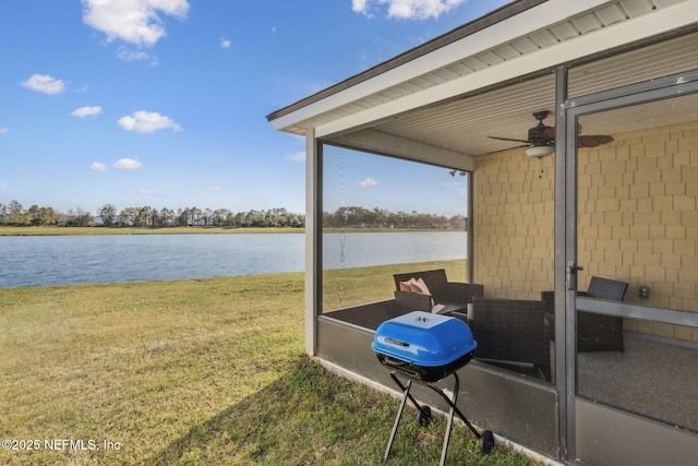 exterior space with a grill, a ceiling fan, and a water view