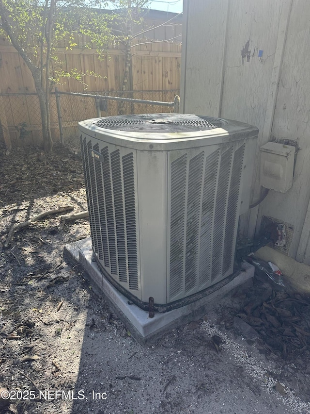 exterior details featuring cooling unit and fence