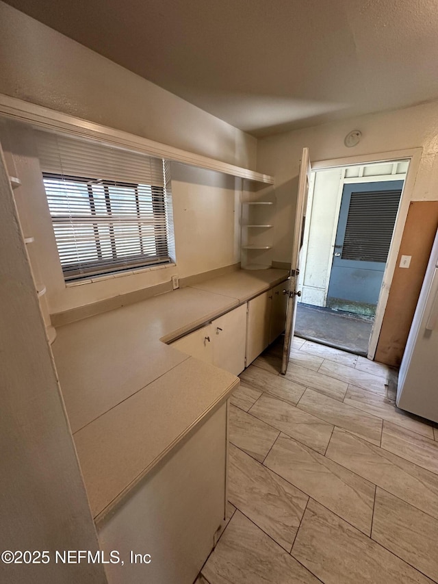 interior space with open shelves, white cabinets, and light countertops