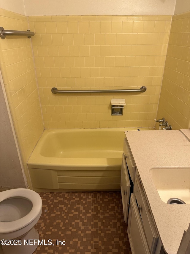 bathroom with toilet, vanity, and shower / tub combination