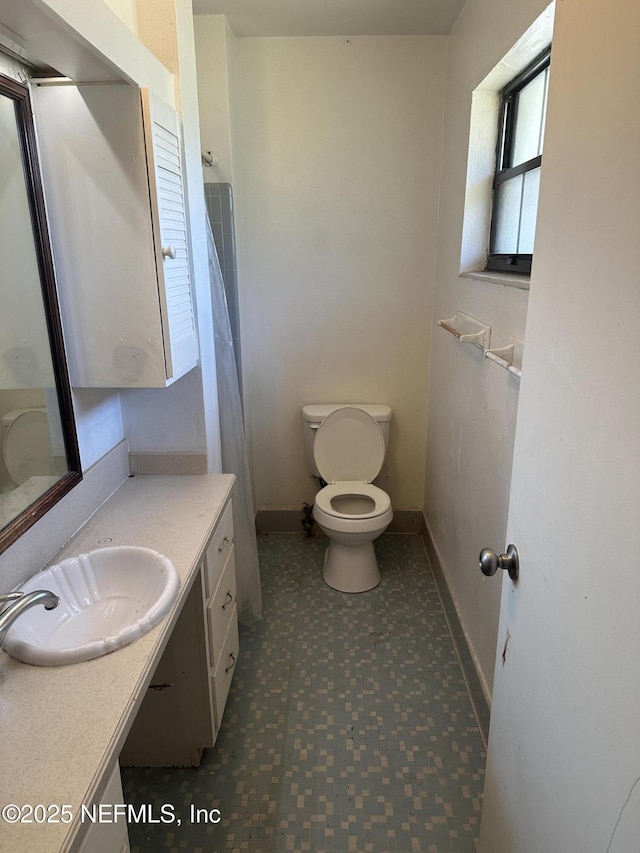 bathroom with tile patterned floors, baseboards, toilet, and vanity