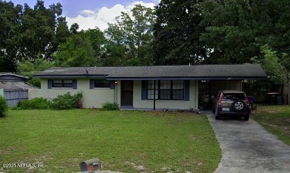 ranch-style home with a carport, a front yard, and driveway