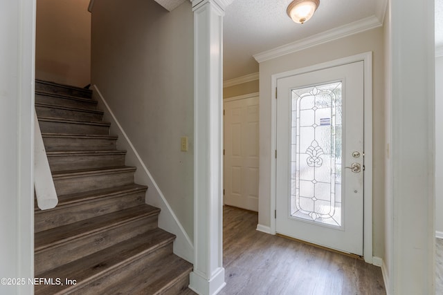 entrance foyer featuring stairway, plenty of natural light, wood finished floors, and ornamental molding