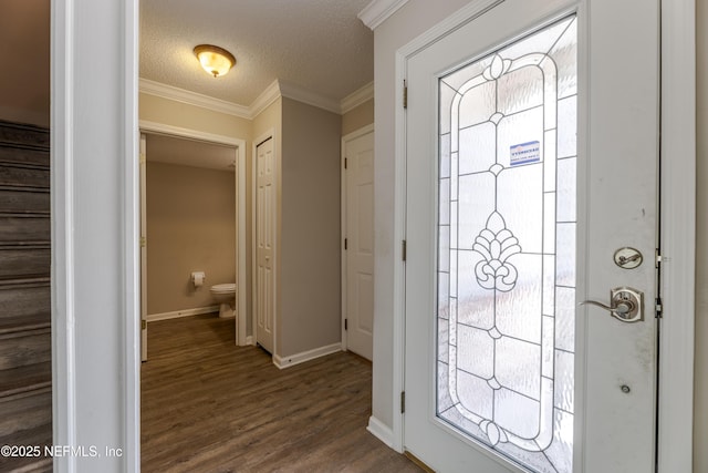 foyer entrance with ornamental molding, a textured ceiling, dark wood finished floors, stairway, and baseboards