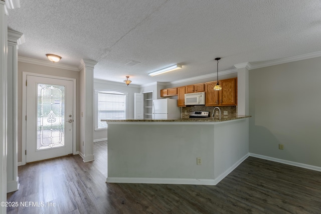 kitchen with dark wood finished floors, decorative backsplash, a peninsula, brown cabinetry, and white appliances