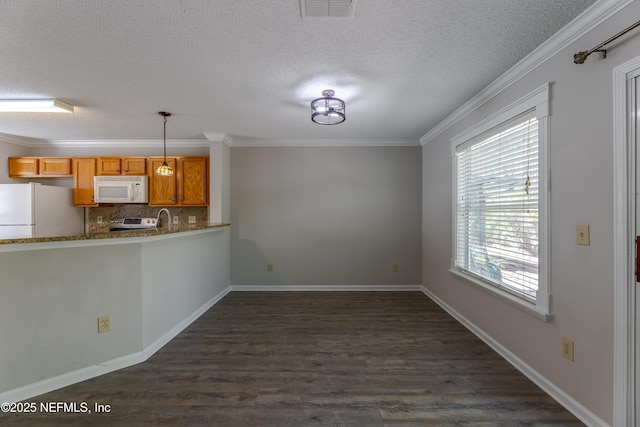 kitchen with white appliances, visible vents, dark wood finished floors, ornamental molding, and decorative backsplash