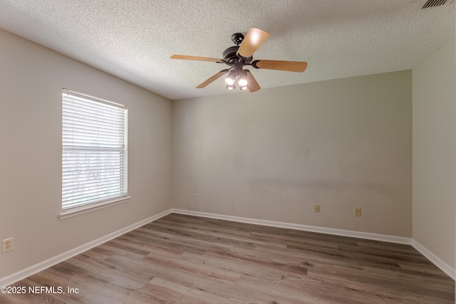 unfurnished room with ceiling fan, baseboards, a textured ceiling, and wood finished floors