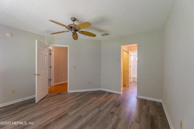 unfurnished bedroom featuring a textured ceiling, wood finished floors, visible vents, and baseboards