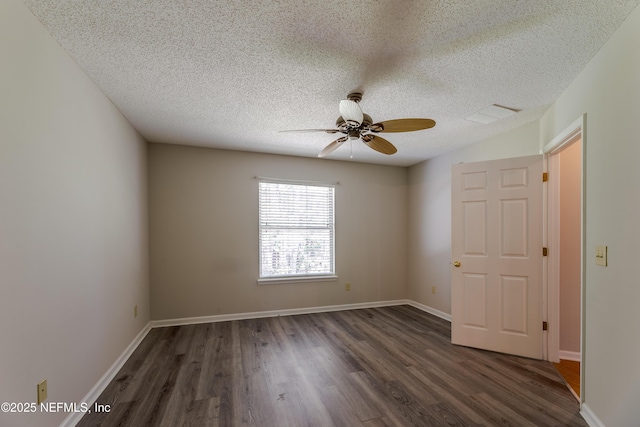 spare room featuring visible vents, a textured ceiling, dark wood-type flooring, and a ceiling fan