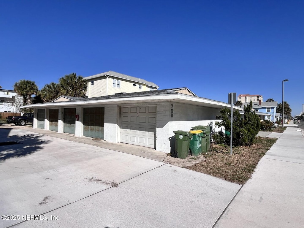 view of side of home featuring community garages and concrete block siding