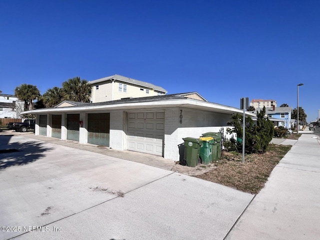 view of side of home featuring community garages and concrete block siding