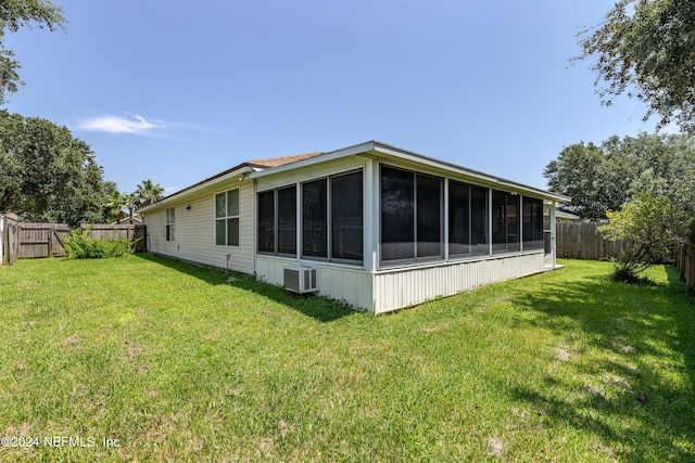 view of property exterior featuring a lawn, a fenced backyard, and a sunroom