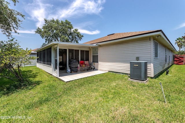 rear view of house with a patio, cooling unit, a yard, and a sunroom