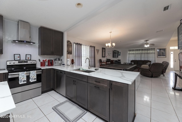 kitchen with visible vents, appliances with stainless steel finishes, a peninsula, wall chimney exhaust hood, and a sink