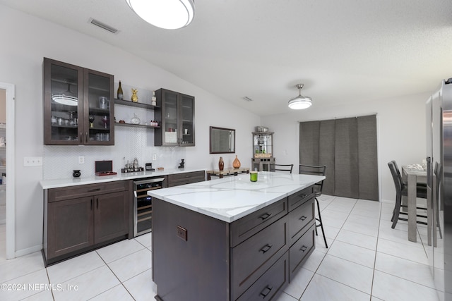 kitchen with wine cooler, light tile patterned flooring, visible vents, and backsplash