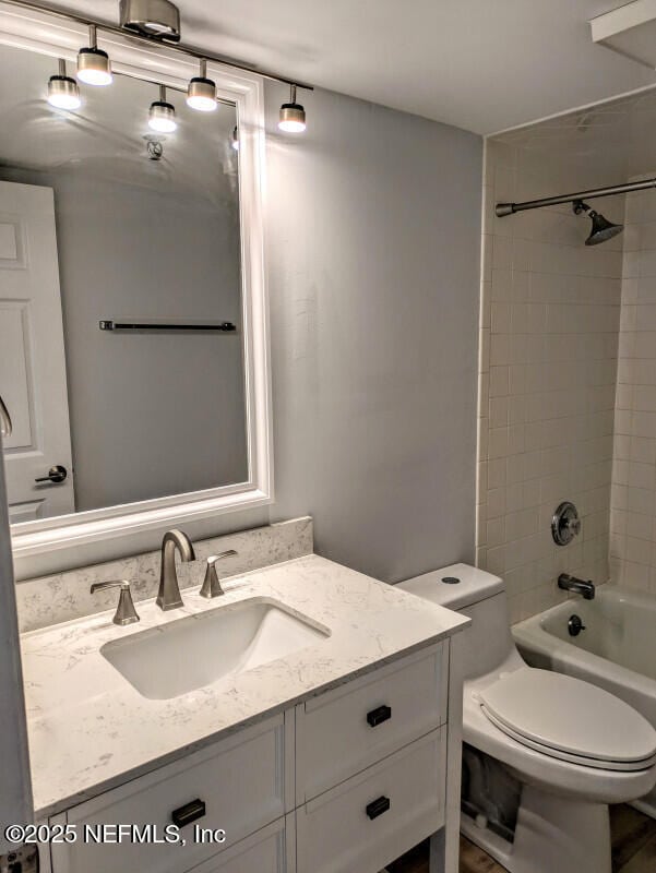 full bathroom with toilet, vanity, and shower / tub combination