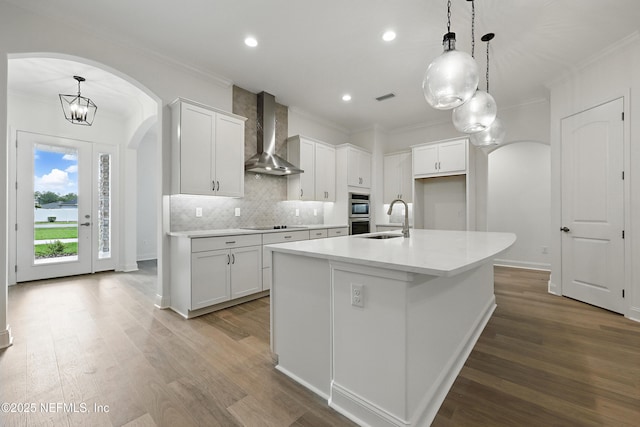 1646 County Road 315b, Green Cove Springs, FL 32043 - kitchen with wood finished floors, a sink, arched walkways, and wall chimney exhaust hood