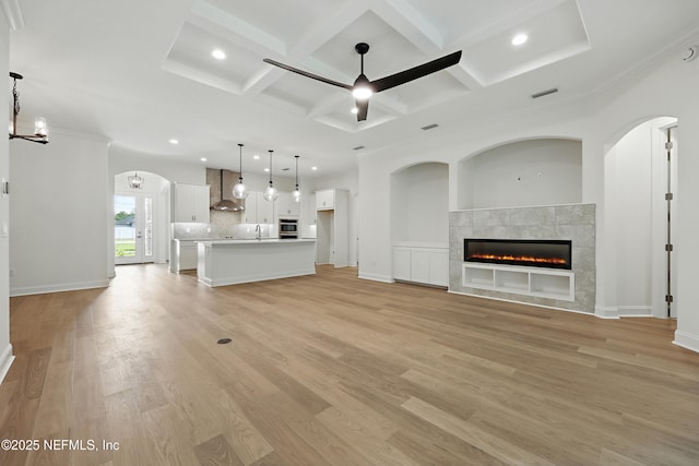 1646 County Road 315b, Green Cove Springs, FL 32043 - unfurnished living room featuring ceiling fan with notable chandelier, coffered ceiling, light wood finished floors, and visible vents