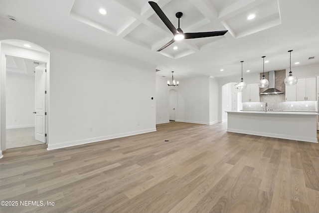 1646 County Road 315b, Green Cove Springs, FL 32043 - unfurnished living room featuring coffered ceiling, recessed lighting, ceiling fan with notable chandelier, arched walkways, and light wood finished floors