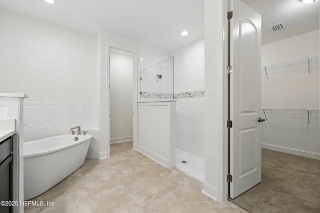 1646 County Road 315b, Green Cove Springs, FL 32043 - bathroom with a freestanding tub, a walk in shower, vanity, a spacious closet, and visible vents