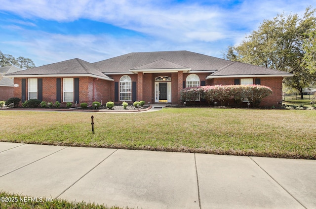 single story home featuring brick siding and a front yard