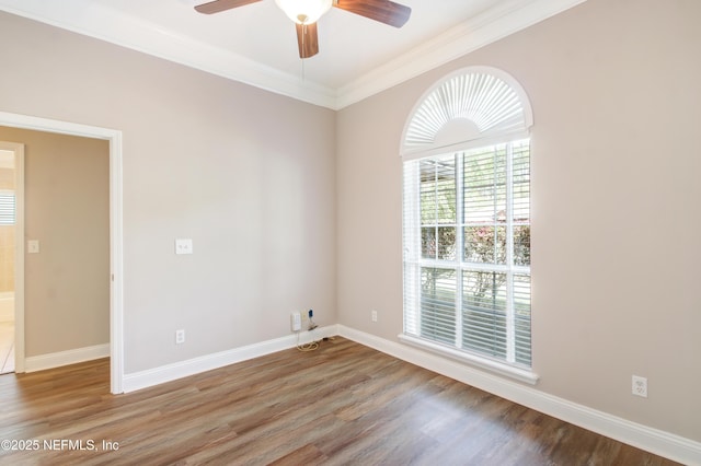 spare room featuring ornamental molding, baseboards, ceiling fan, and wood finished floors